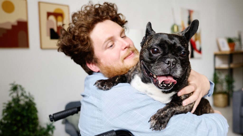 A man looks calm as a goofy dog pants on his shoulder