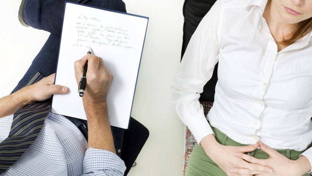 Overhead image of a therapist, his notepad, and a patient