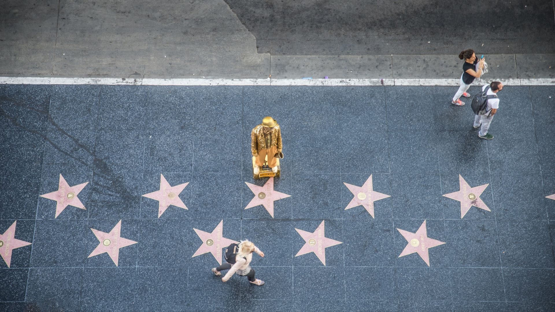 An overhead view of a man clad in gold on the Hollywood walk of stars