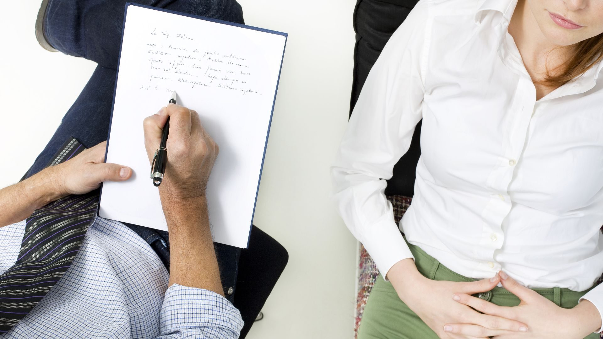 Overhead image of a therapist, his notepad, and a patient