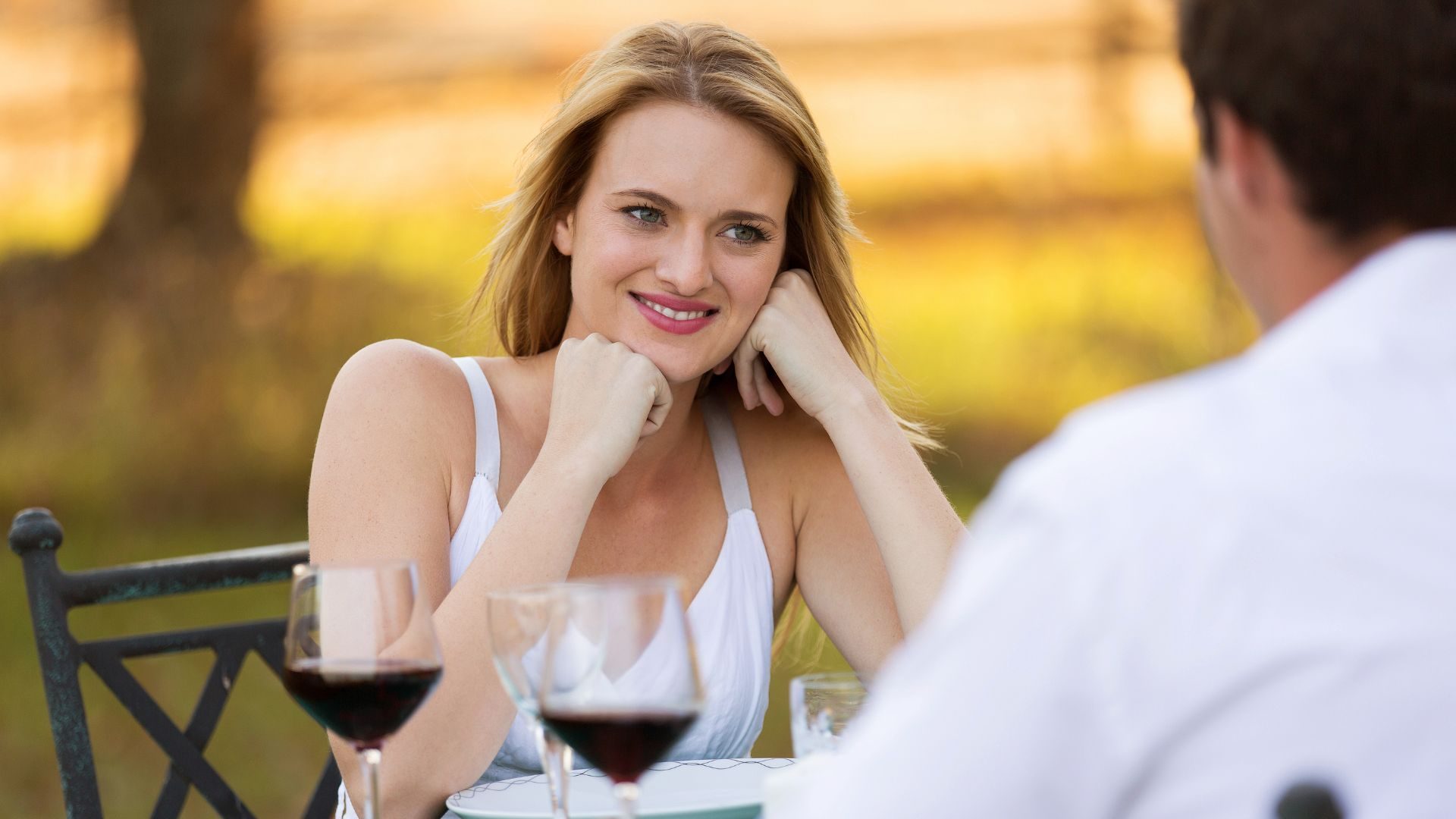 A content woman looks across a restaurant table at her date
