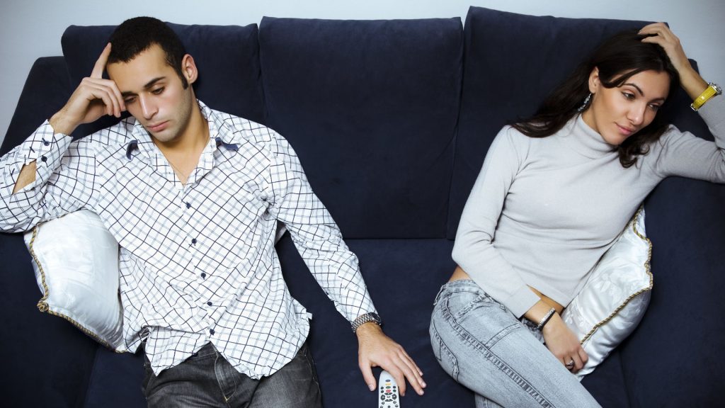 A couple of a couch looking in two difference directions